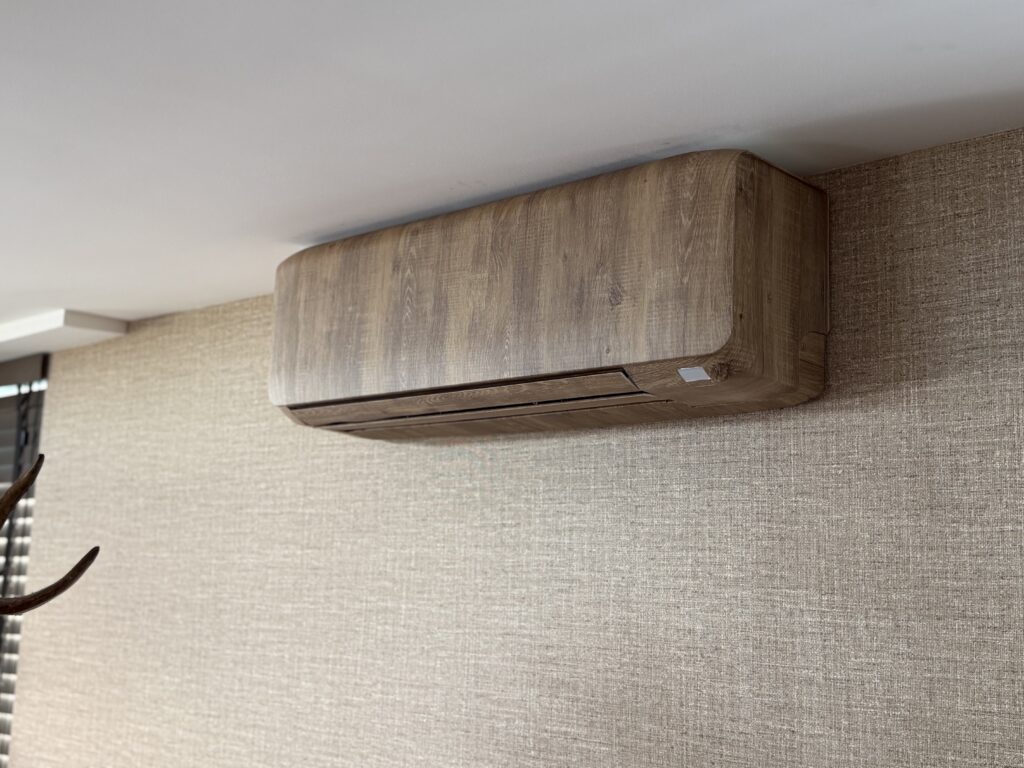 Airco gewrapt in eikenhout-look tegen een linnen wand