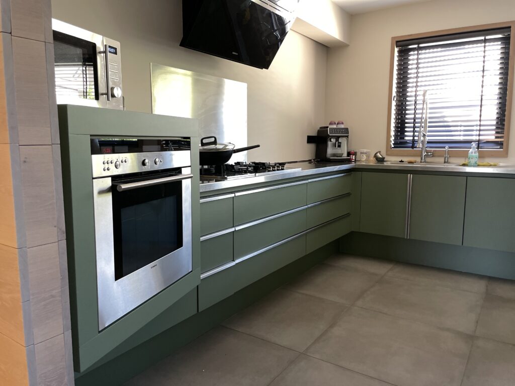Keuken gewrapt in mat groene folie met rvs werkblad